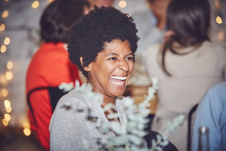 guest laughing at wedding speeches at festival style barn wedding in devon
