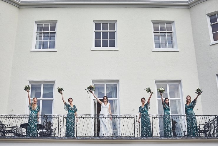 bridal party waving from balcony at a mini wedding at Rockbeare Manor in Devon