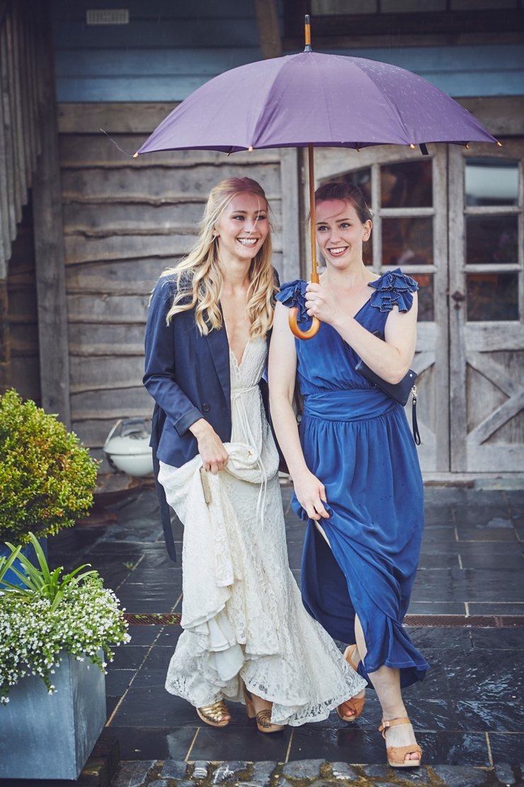 bride leaving for wedding venue under umbrella at devon wedding